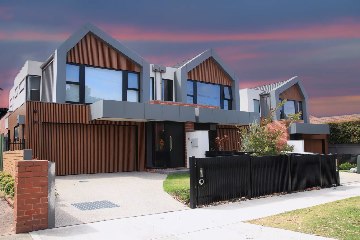 Row of two-storey timber-clad townhouses at dusk in Melbourne's west